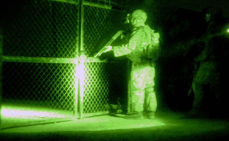 Army Soldier breaches gate with shotgun using M1030 breaching munition during raid in Mushada, Iraq on June 11, 2007. Frangible design of munition minimizes ricochet hazards currently associated with buckshot breaching and provides much safer alternative to Soldiers. Photo: U.S. Army photo by Staff Sgt. Antonieta Rico / Released