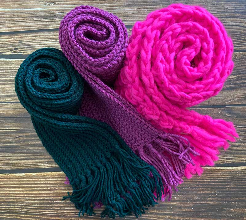 top view of a green, purple, and pink scarves