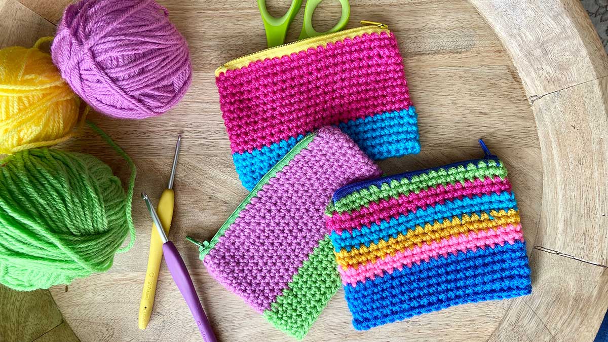 3 crochet zipper pouches with yarn and crochet hooks