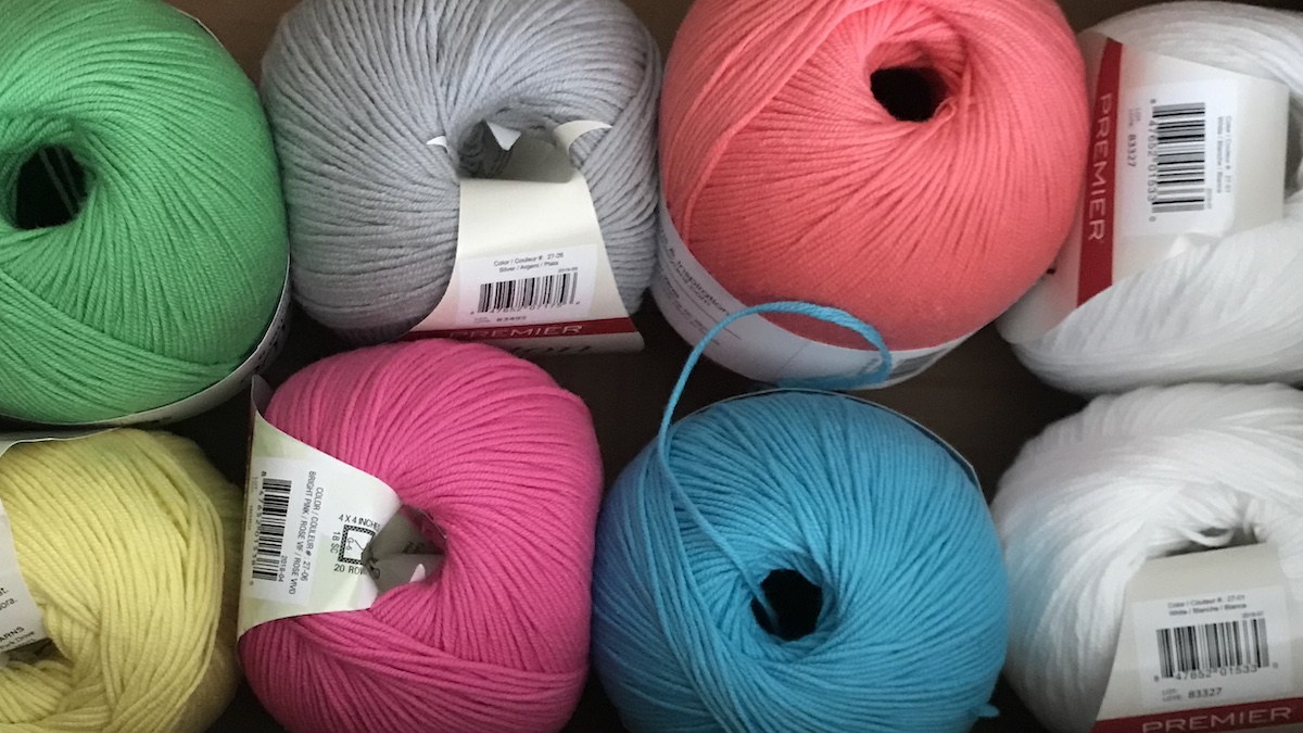 8 balls of premier yarn in various color in a top down view