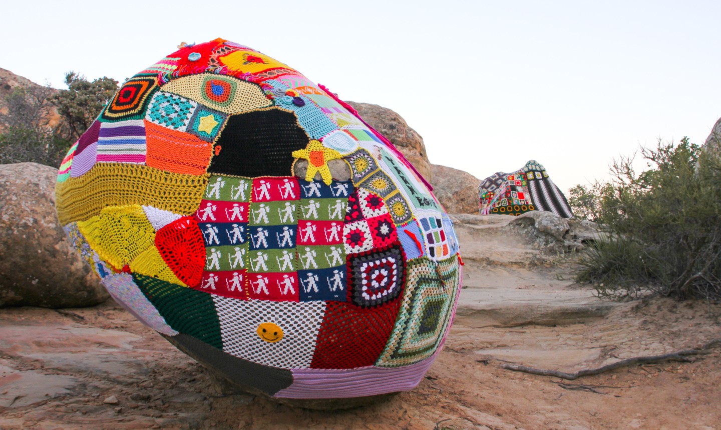 Colorful crochet knit on a tree trunk yarn bombing. Patchwork