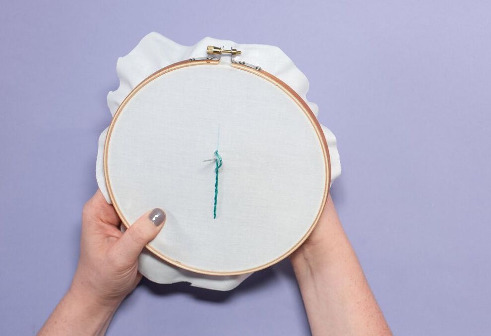 Women holding green stem stitch embroidery