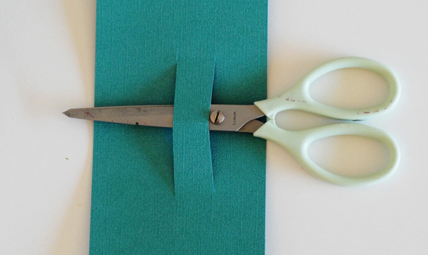 scissors cutting slit in paper