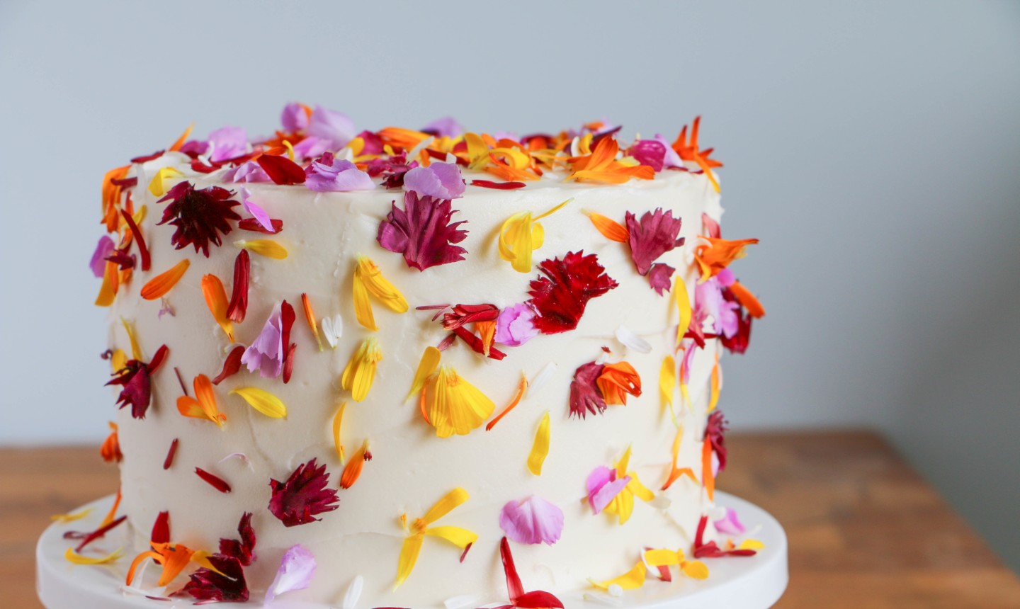 white cake covered in flower petals