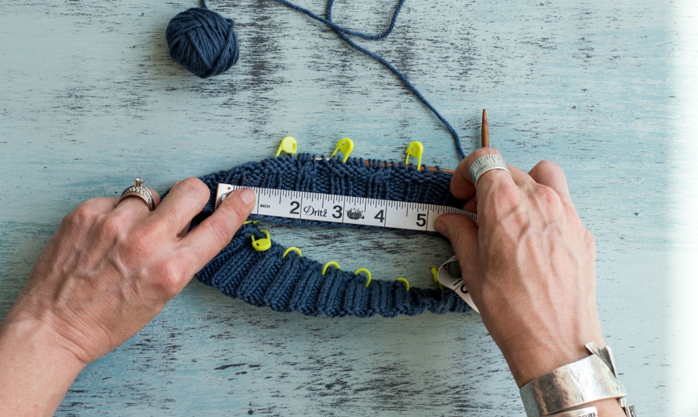 woman measuring gauge of in the round project