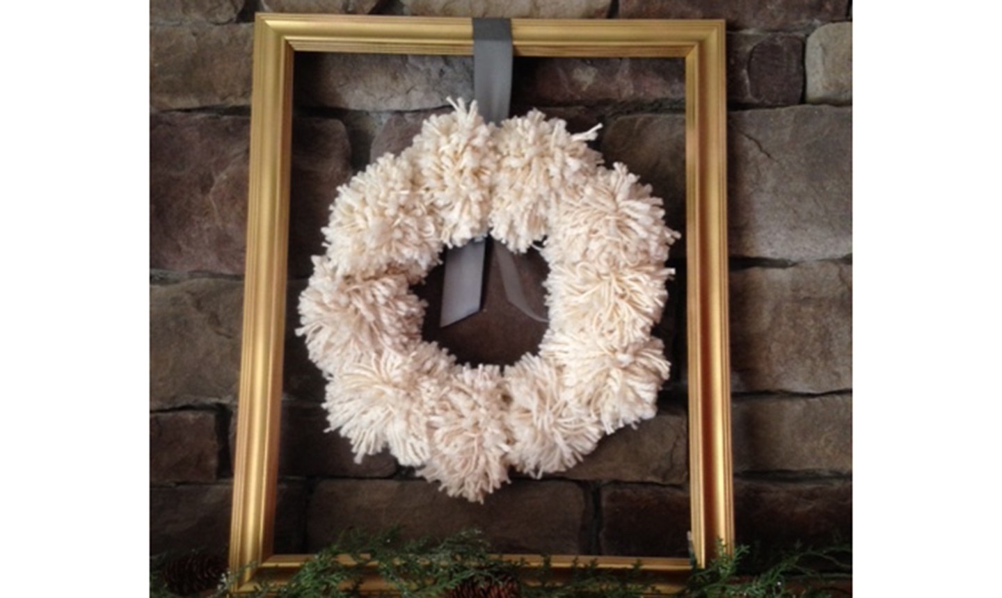 white pom pom wreath in a frame