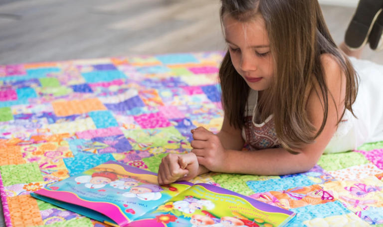 child reading on a quilt