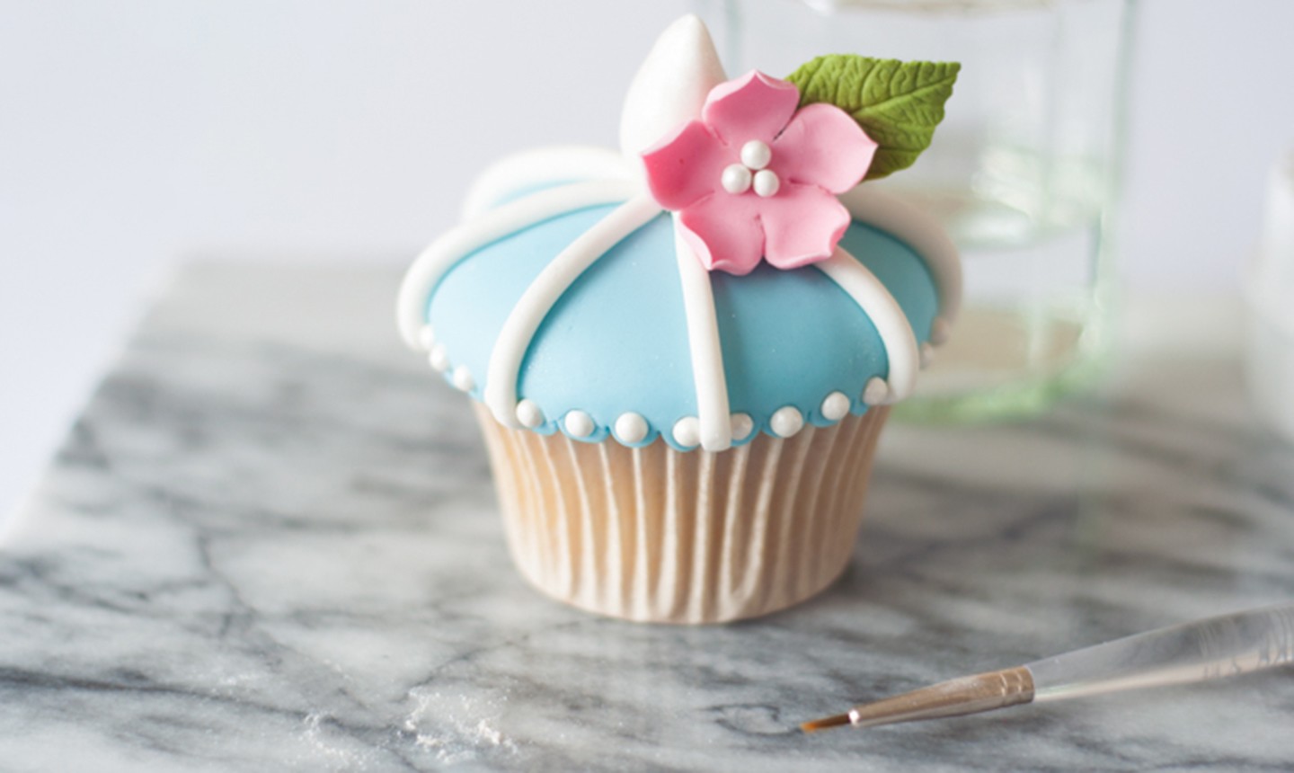 fondant flower on blue cupcake