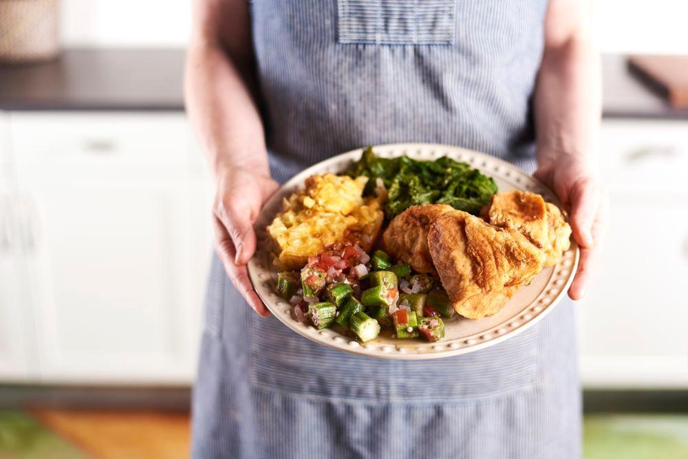 woman holding plate of southern food