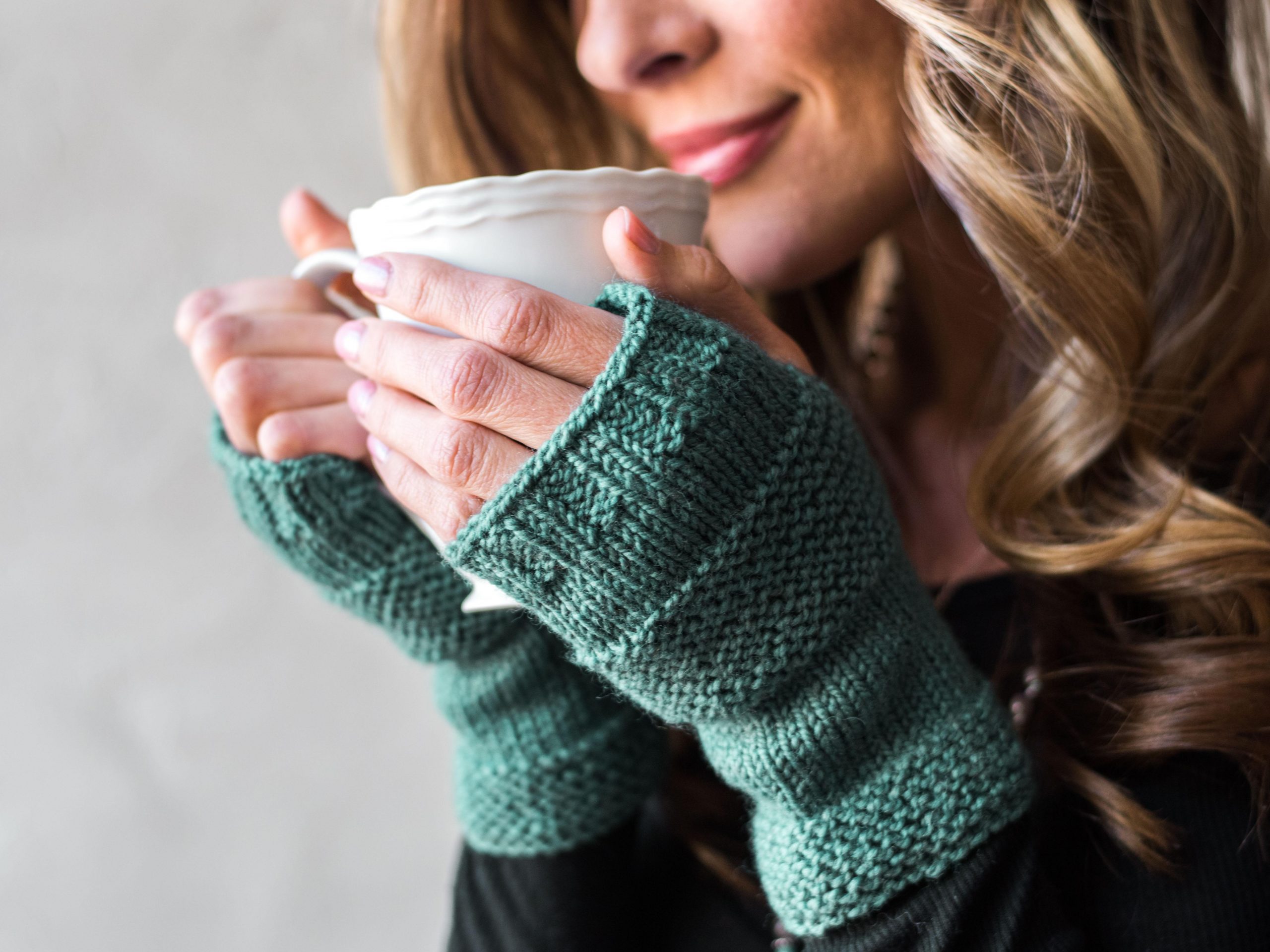 Woman wearing green fingerless gloves