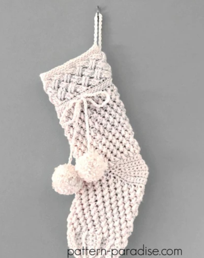 white crocheted stocking with pom poms