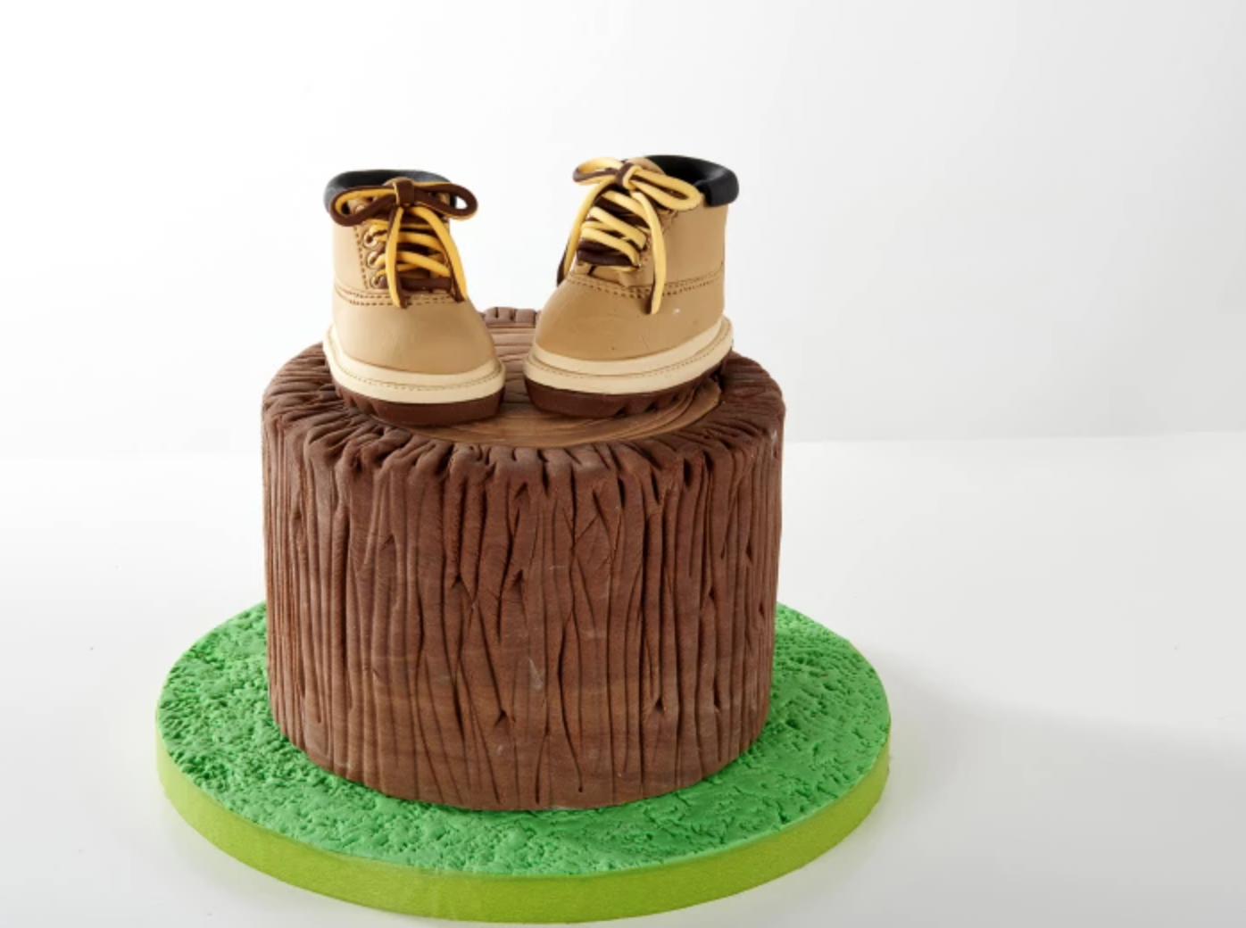 sculpted tree stump cake with little shoes