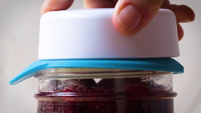 pressing lid on pickled cranberries