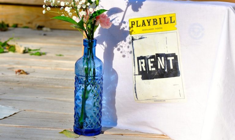 Flowers in front of Rent playbill on fabric