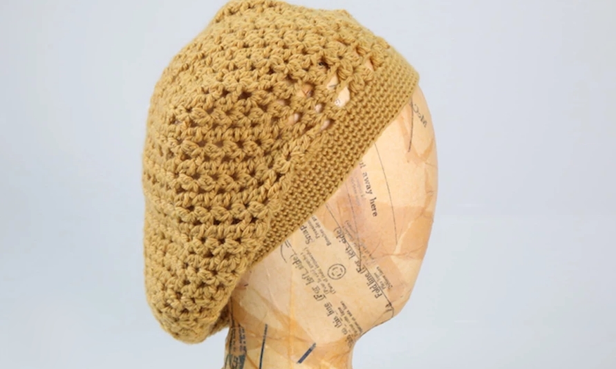 Yellow crocheted beret on a mannequin head