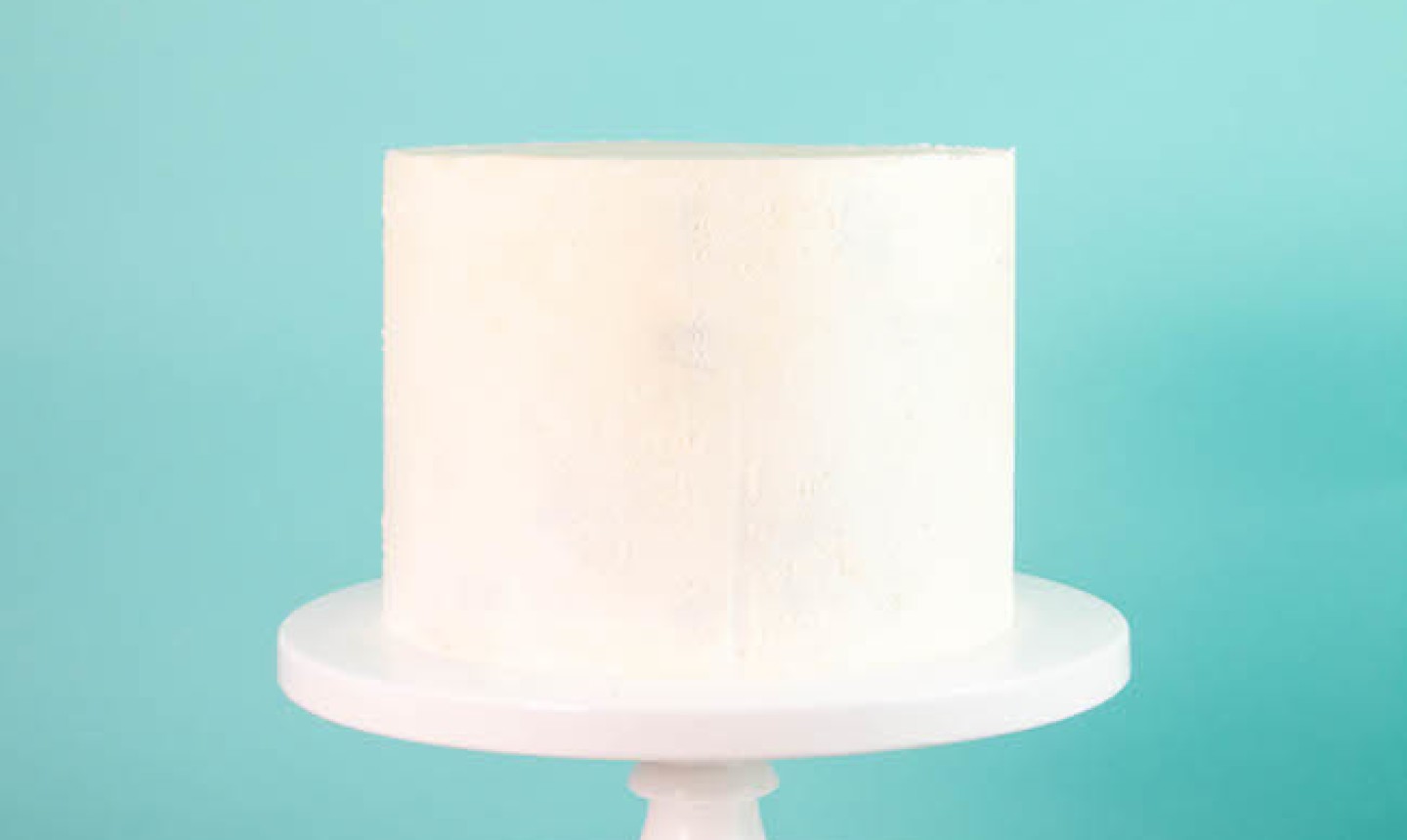 Cake with white frosting on a pedestal