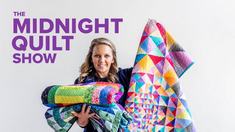 Woman posing with quilts