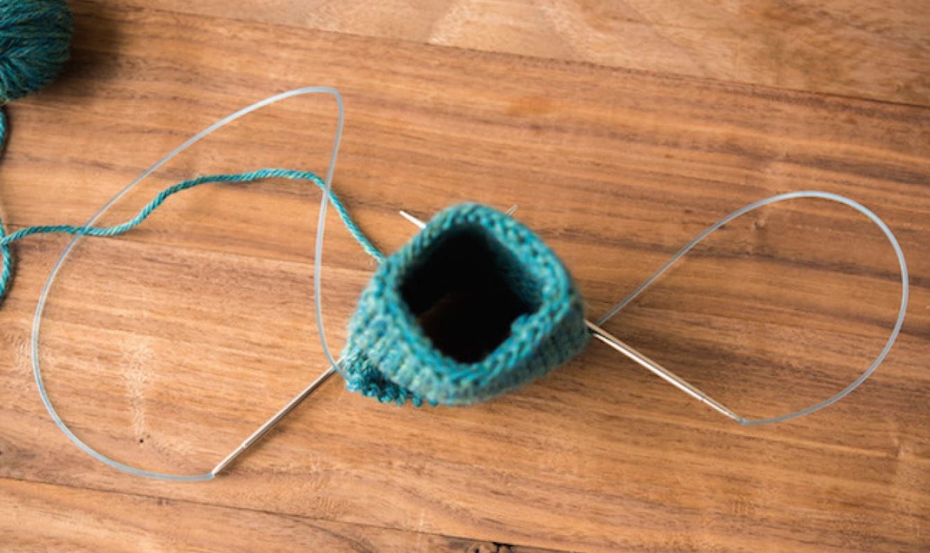 Use a pair of circular knitting needles to create round knit work.