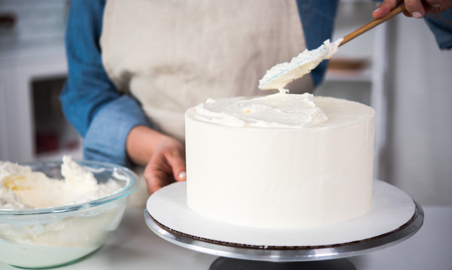 Putting frosting a cake