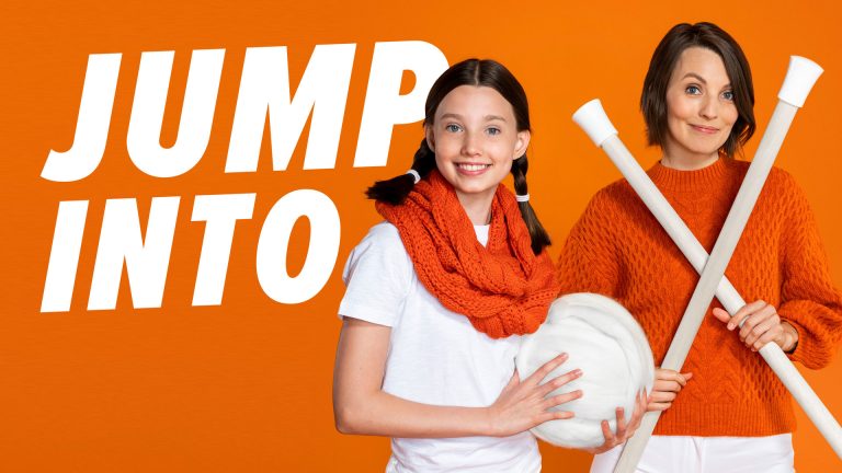 Woman and girl holding large knitting props