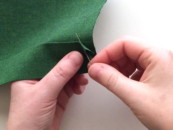 Pinning corner of green fabric