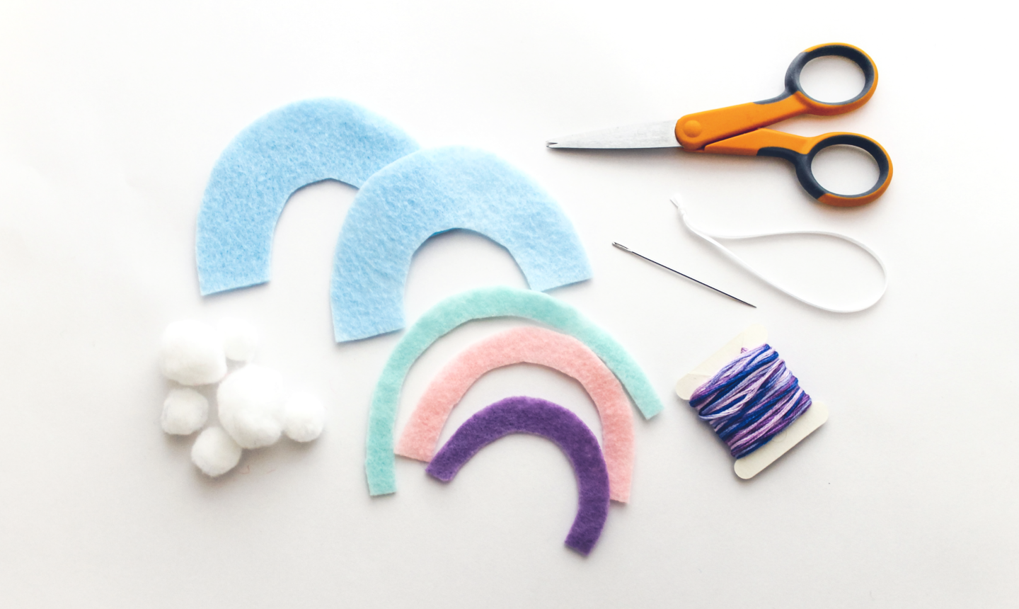 cutting out rainbow felt ornament arcs