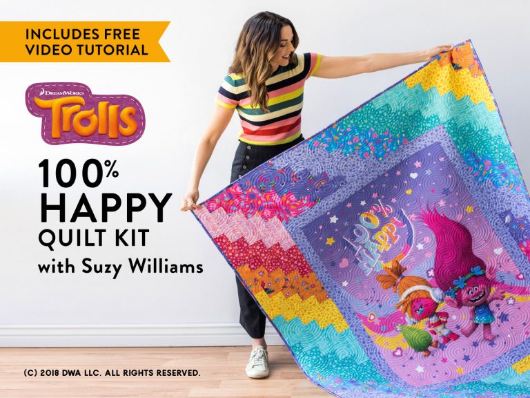 Woman holding up a Trolls quilt