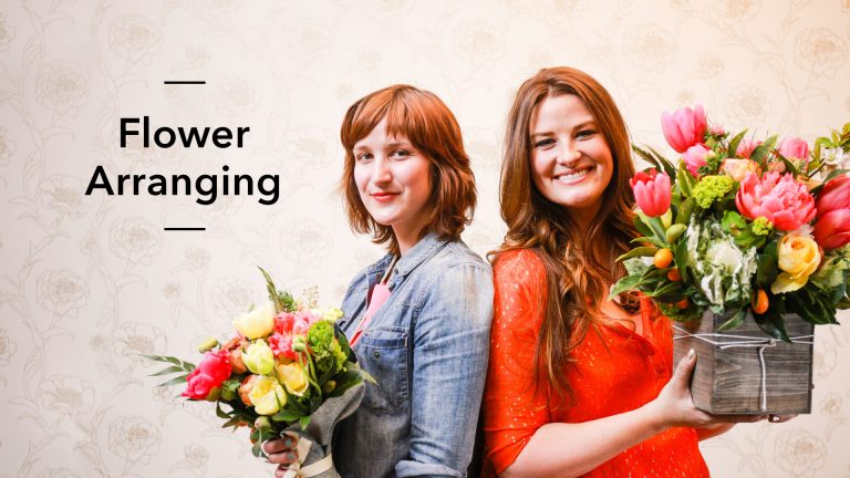 Two woman holding flower arrangements