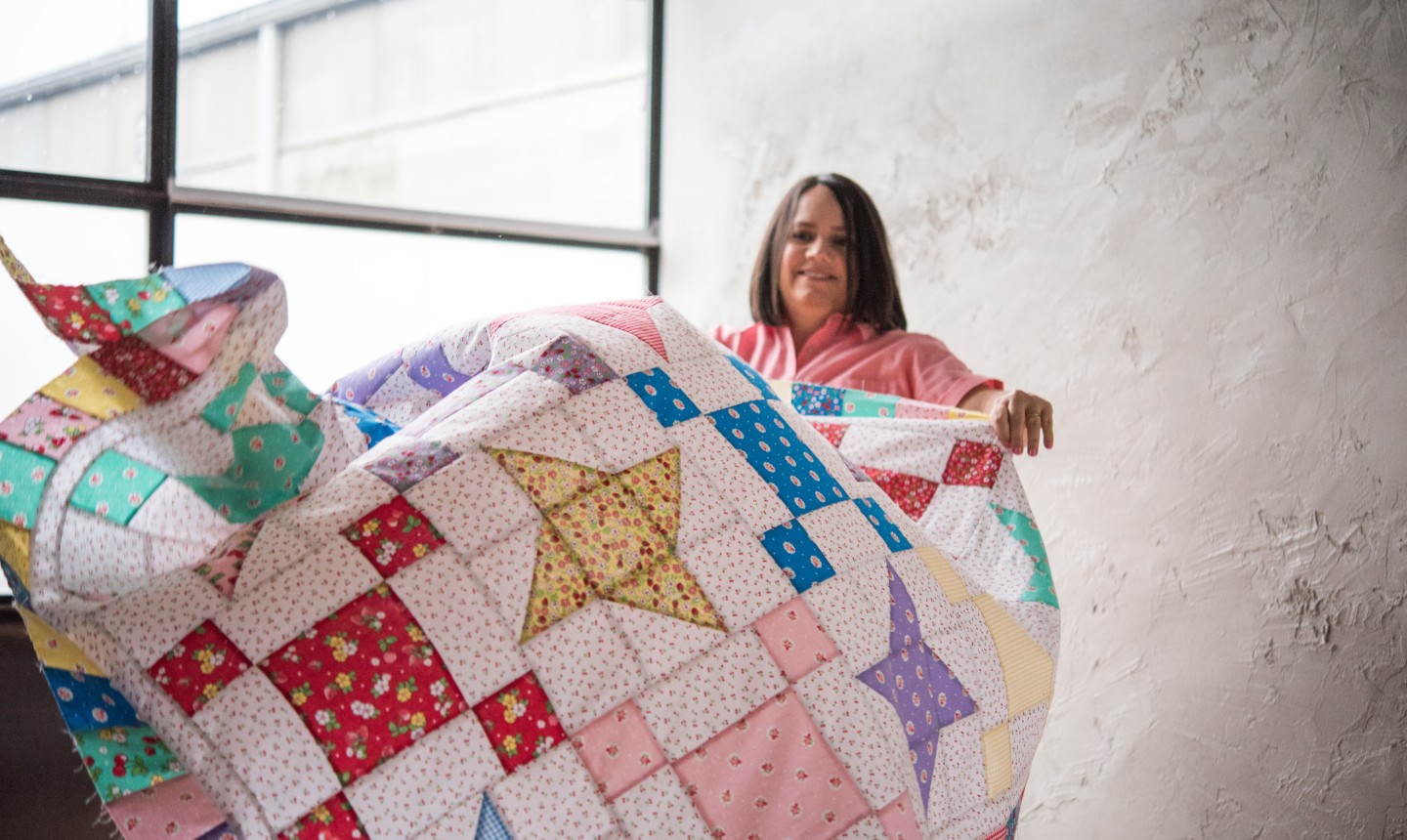 woman draping quilt top