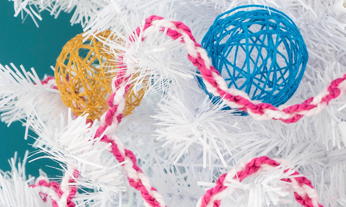 yarn ornaments and garland in a white christmas tree