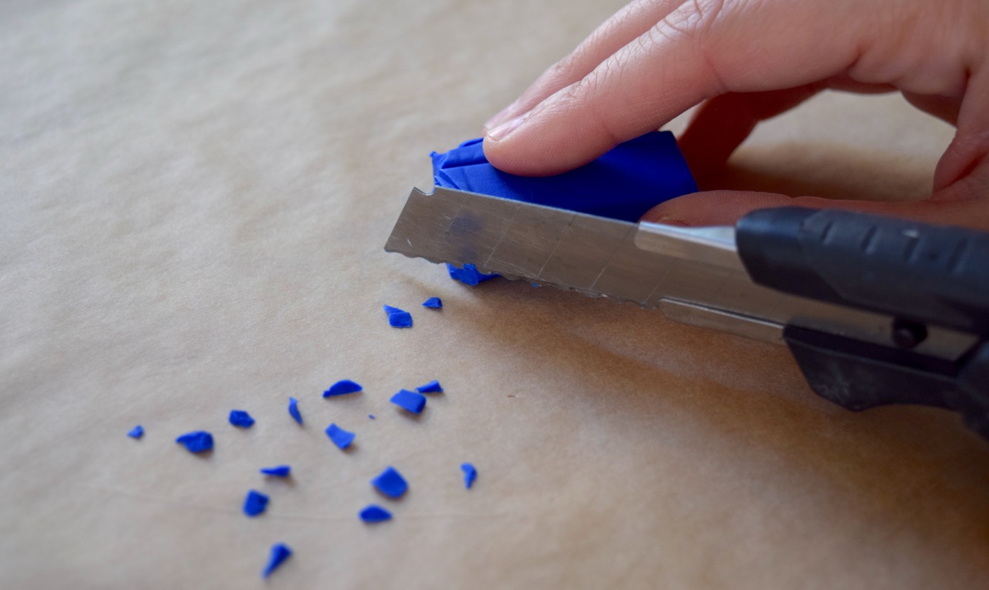 cutting small bits of blue clay