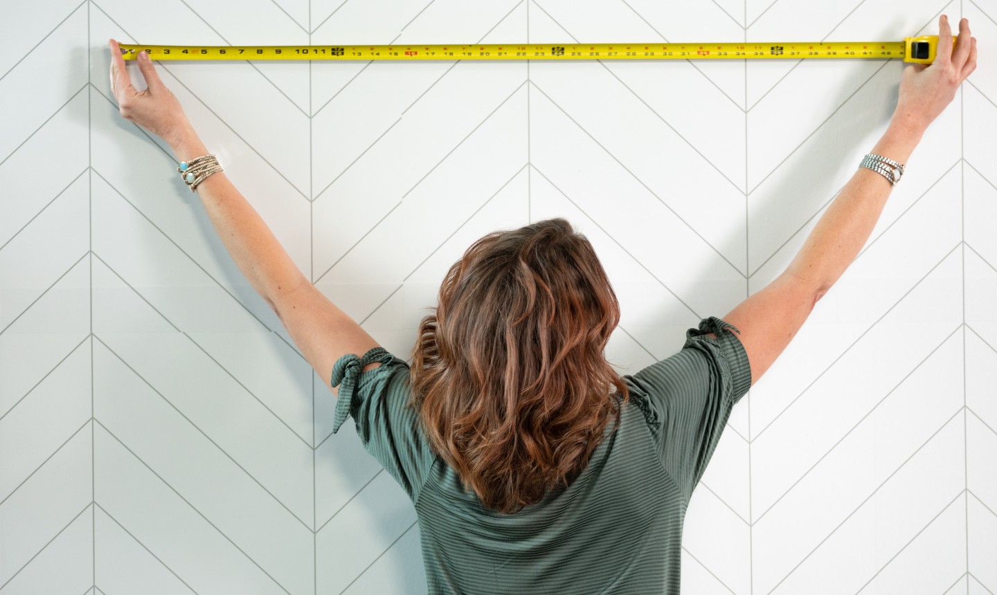 woman measuring a wall