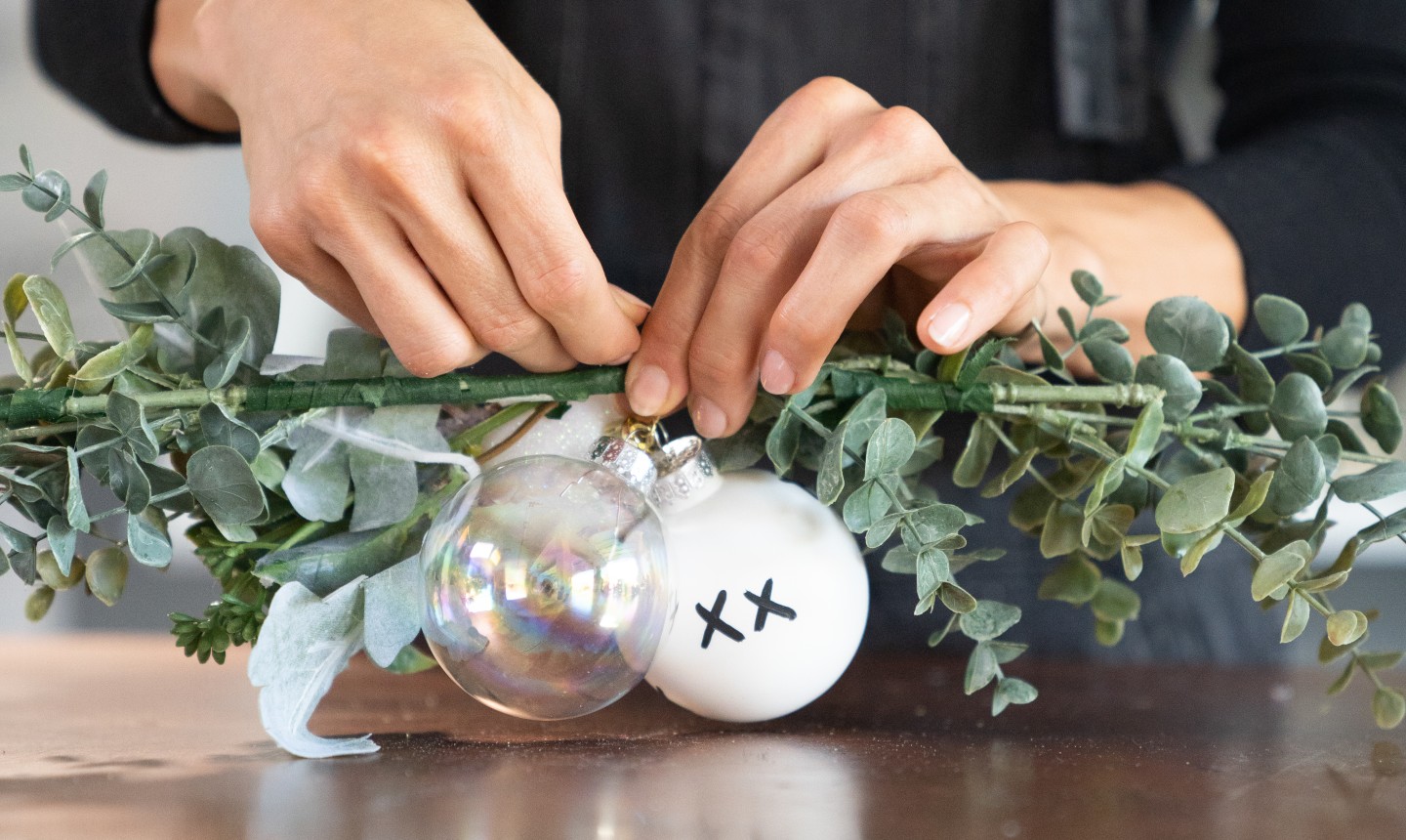 tying ornaments to a wall hanging