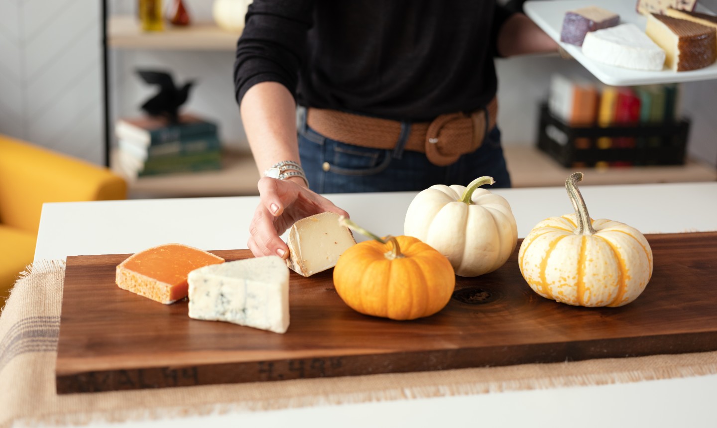 woman placing cheese on cheese board