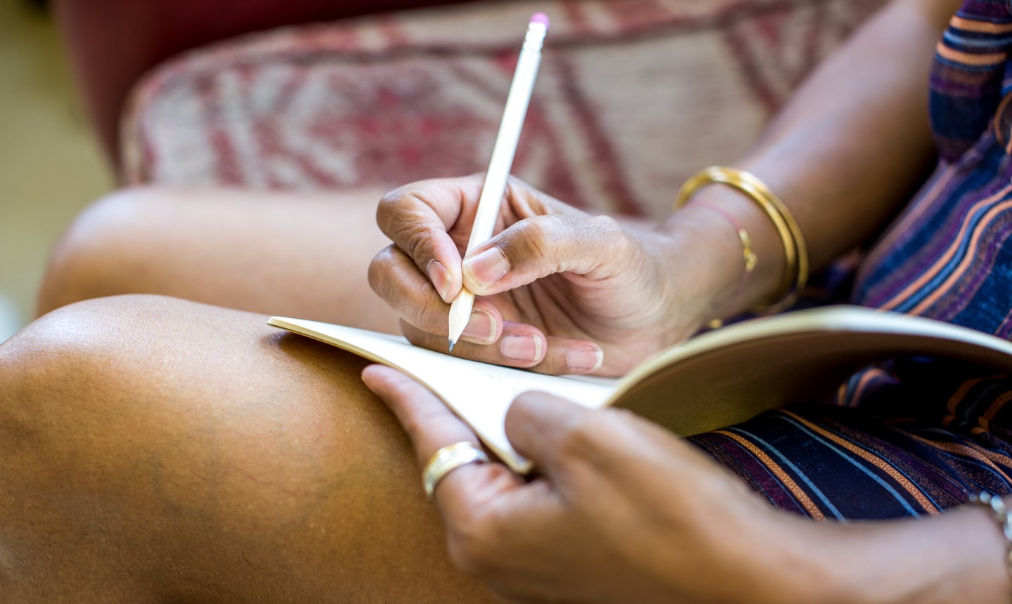 woman journaling with pencil