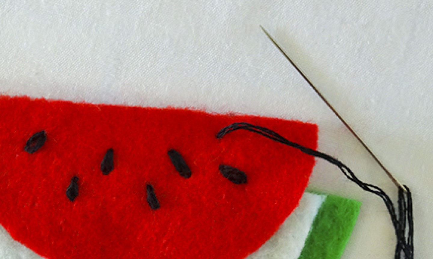 stitching watermelon seeds on felt