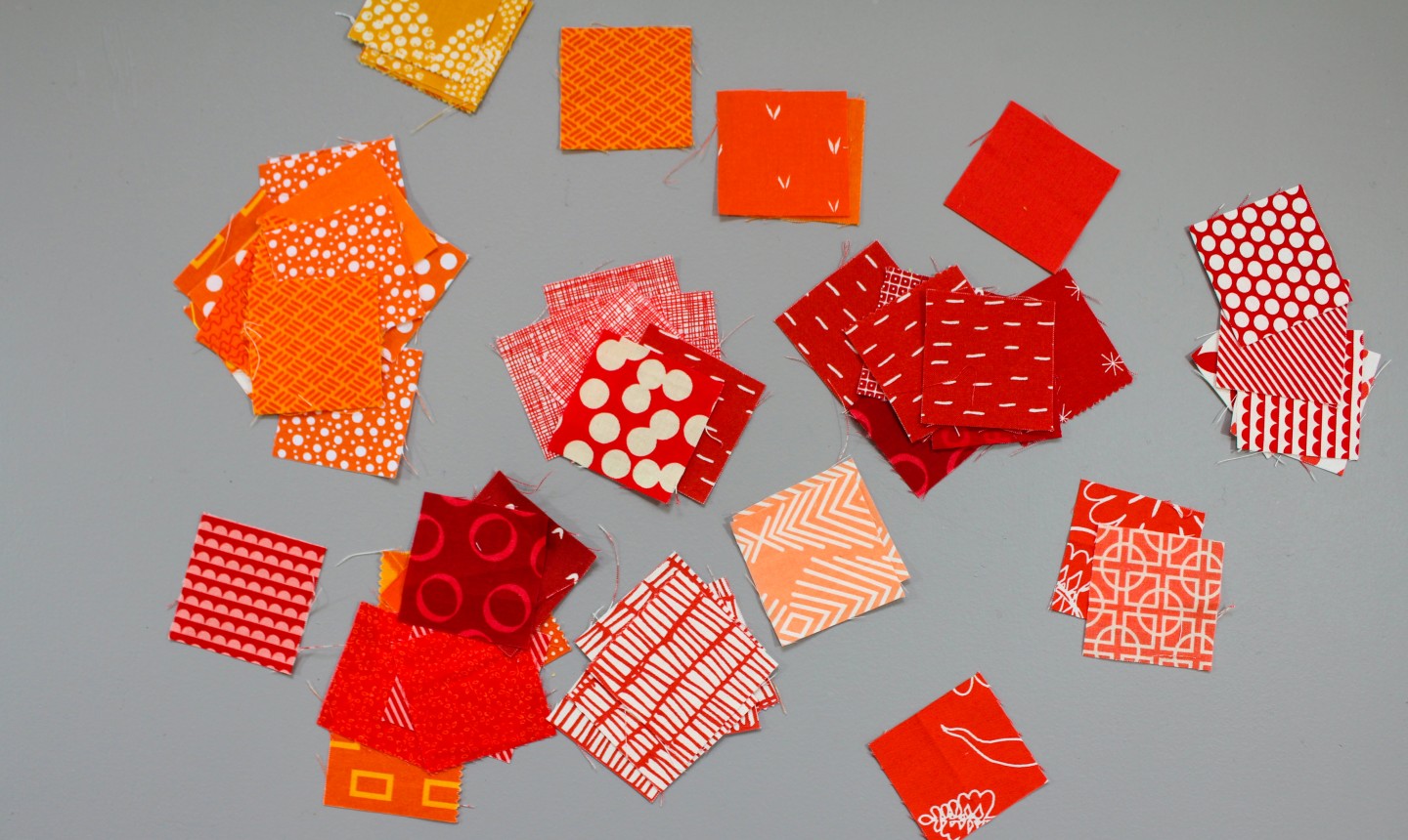 square scraps of red and orange fabric