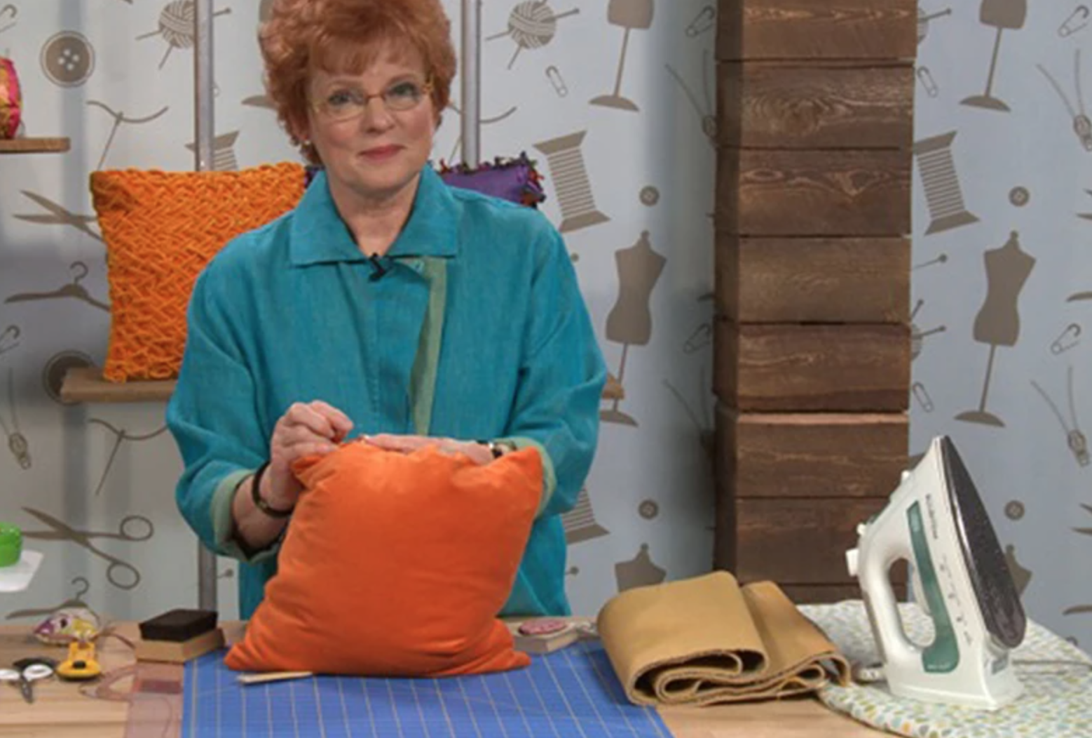 woman sewing orange pillow