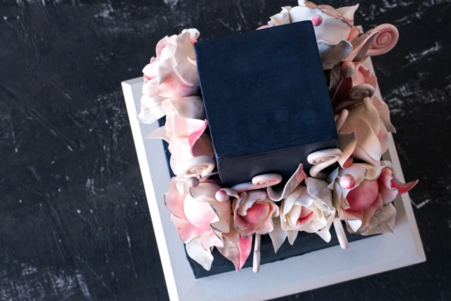 top view of pink white and black floral cake