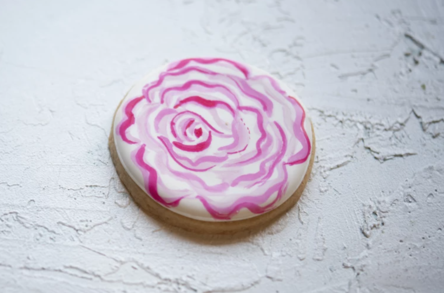 round sugar cookie with rose royal icing