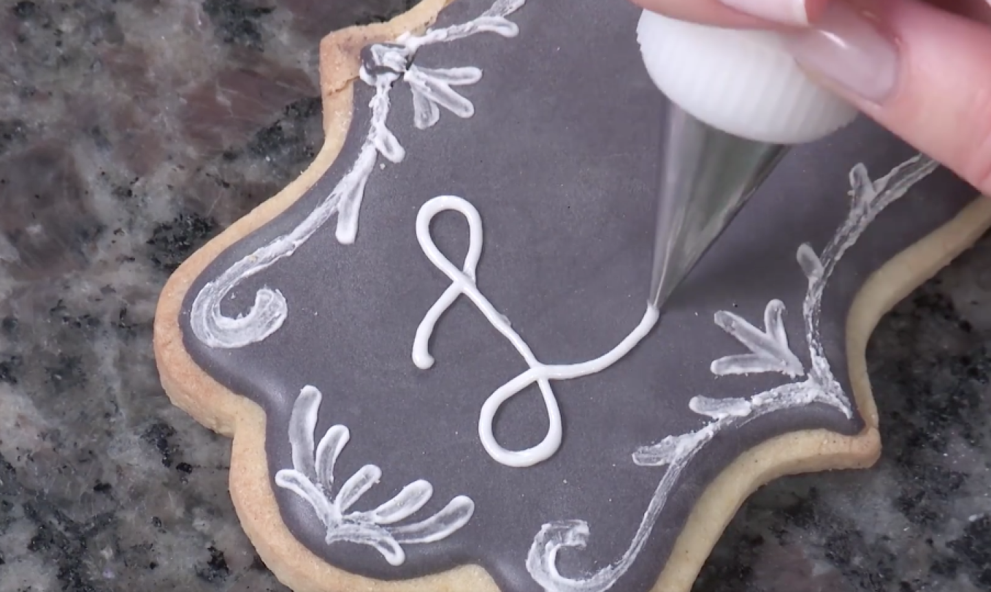 piping words on chalkboard cookie