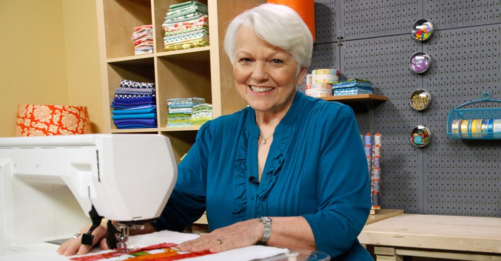 Woman smiling while using a sewing machine