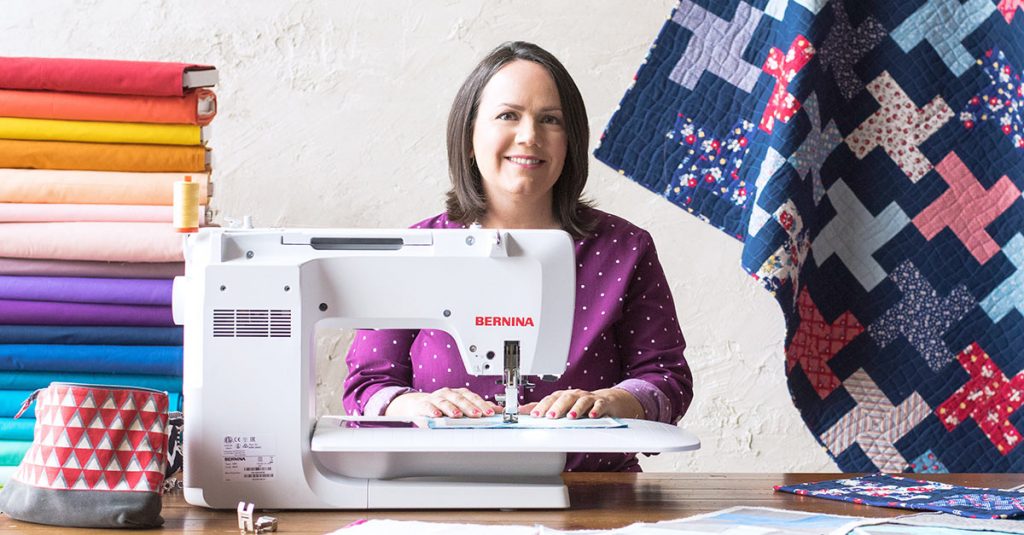 Woman sewing with a sewing machine in front of fabric