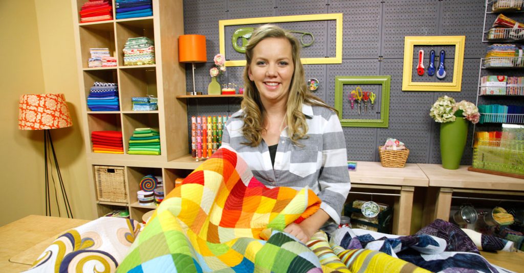 Woman holding a rainbow quilt
