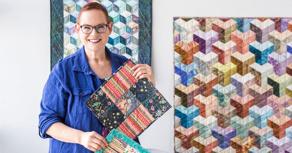 Woman holding up quilt squares