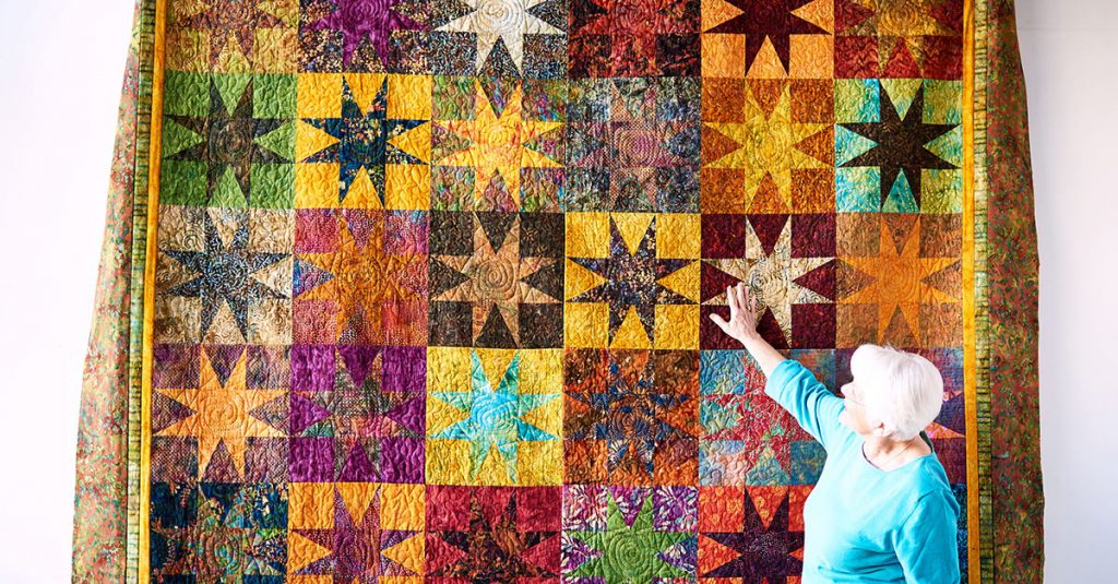 Woman touching star pattern quilt
