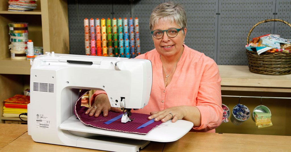 Woman in glasses sewing with a sewing machine