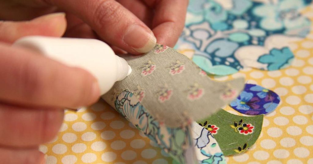 Putting glue on the back of fabric scraps
