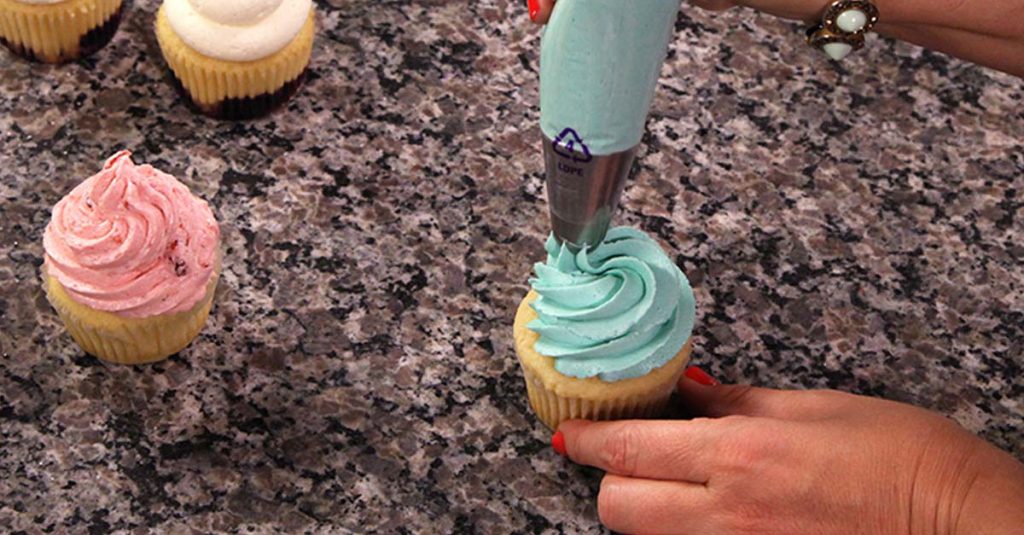 Piping buttercream on a cupcake