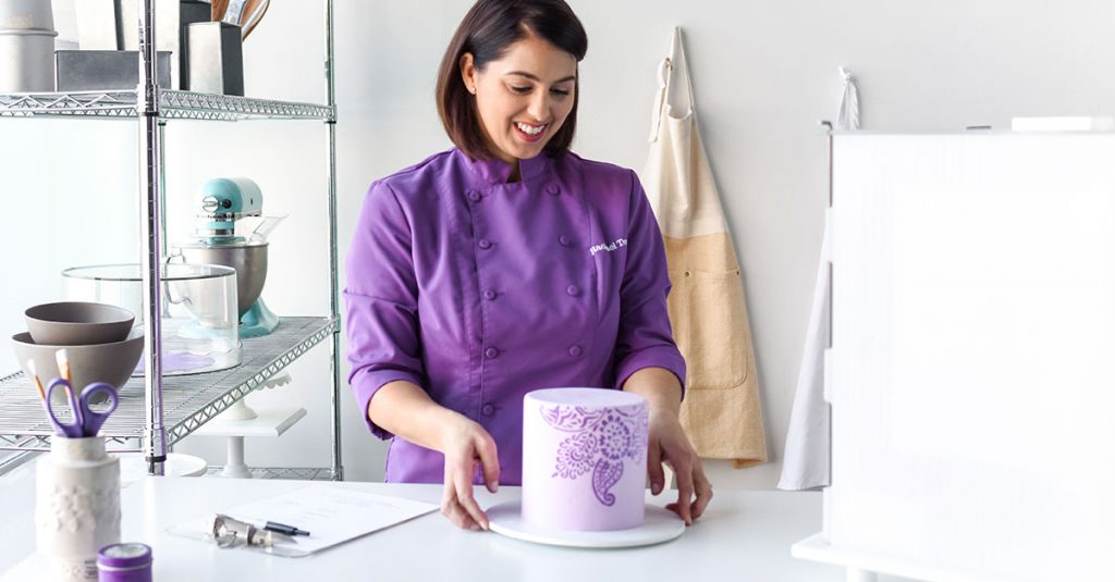 Baker looking at purple cake